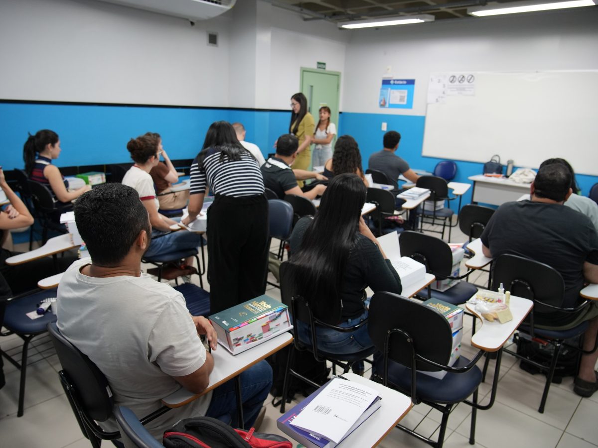 Na imagem vemos um sala de aula de uma universidade, onde candidatos estão fazendo as provas da 2ª fase do concurso da Defensoria