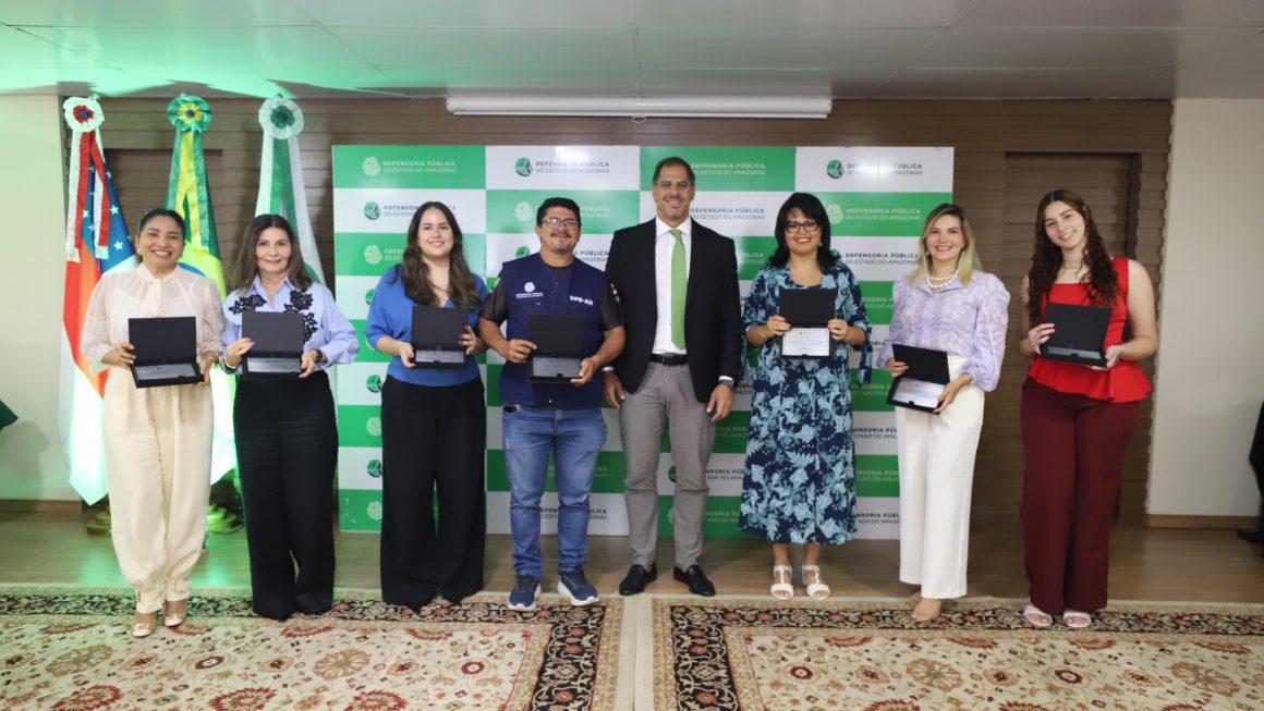 Servidores posam com placas de homenagem