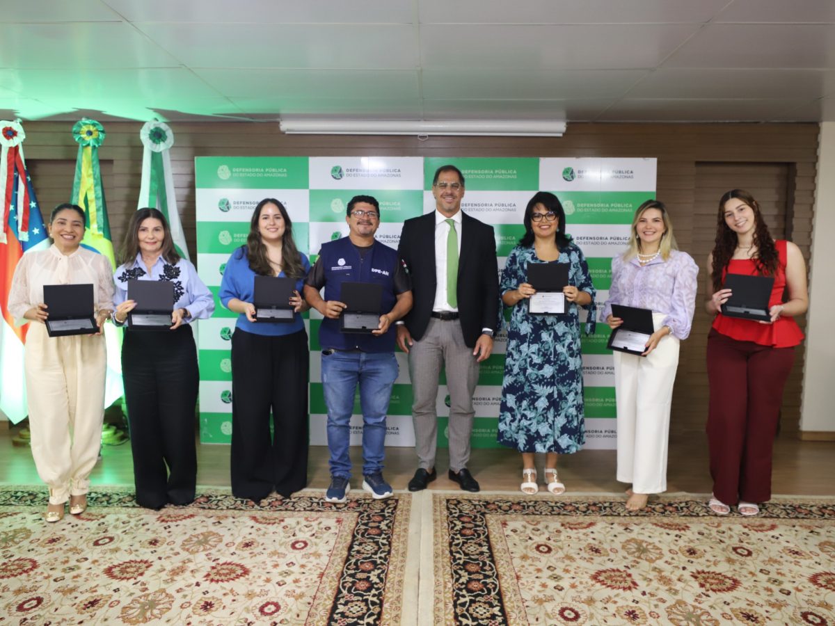 Servidores posam com placas de homenagem