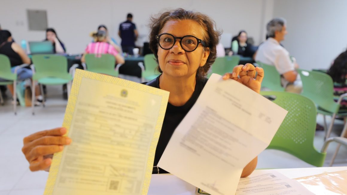 Na foto, vemos a assistida Ivanilde mostrando a certidão de nascimento que foi retificada após mutirão itinerante