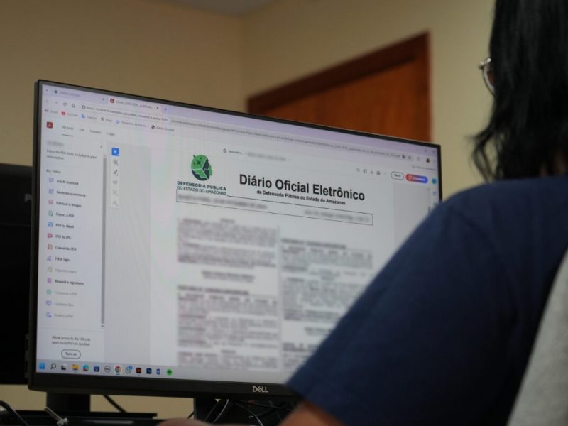 Pessoa lendo o Diário Oficial da Defensoria