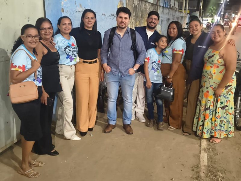 A imagem mostra mães associadas e o defensor Renato Fernandes ao centro, em foto posada, com todos de pé