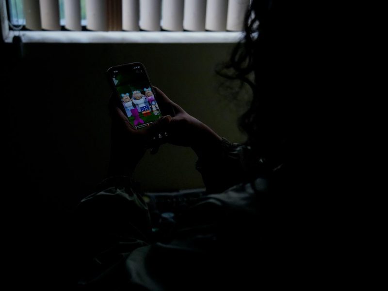 Adolescente com o celular na mão para alerta sobre os perigos no ambiente digital