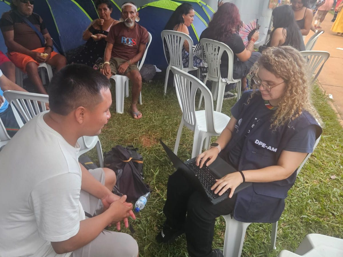 Na imagem, vemos a defensora pública Daniele Fernandes realizando uma atendimento a um indígena no ATL