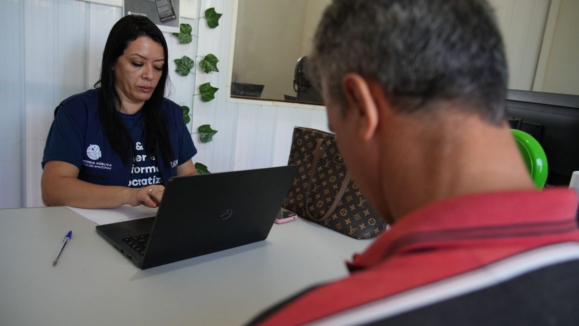 Servidora em frente do computador atendendo a um assistido da Defensoria do Amazonas na unidade de Humaitá