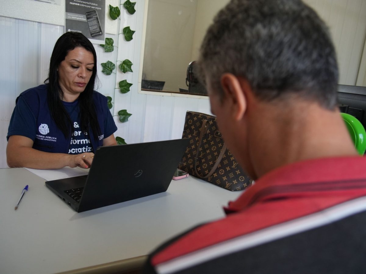 Servidora em frente do computador atendendo a um assistido da Defensoria do Amazonas na unidade de Humaitá